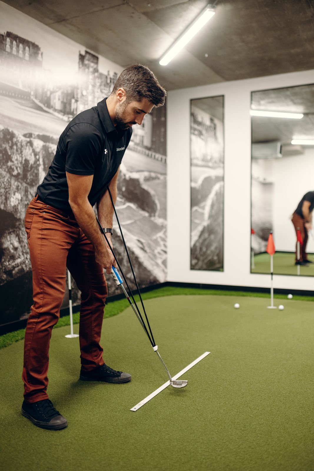 Un joueur pratique son putting sur le vert intérieur